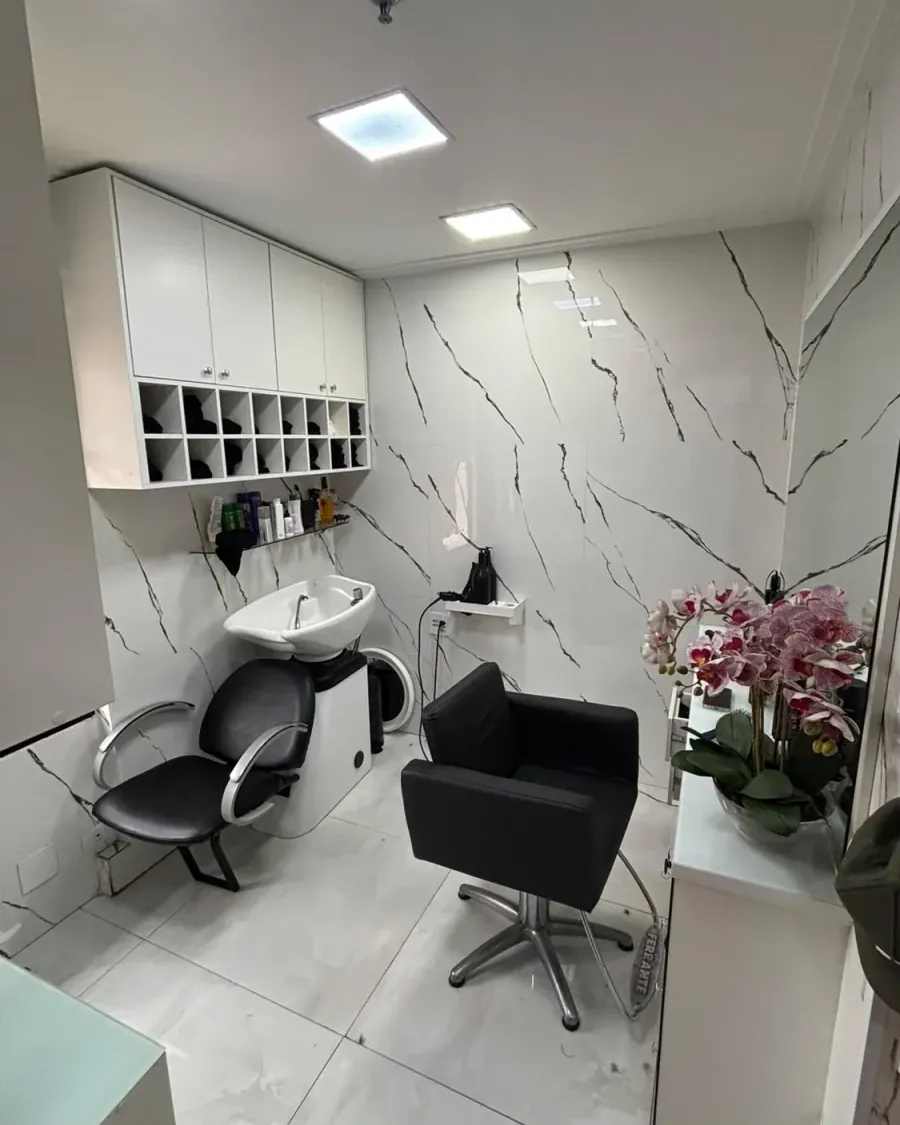 Sala de atendimento real da Recriare Beleza, com bancada branca e cadeiras de salão