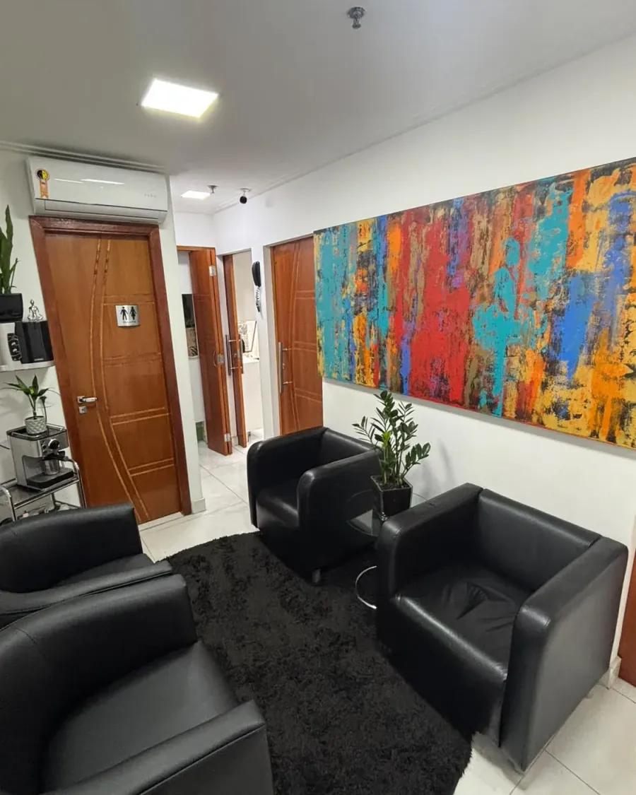 Sala de espera real da Recriare Beleza, com poltronas pretas e quadro colorido